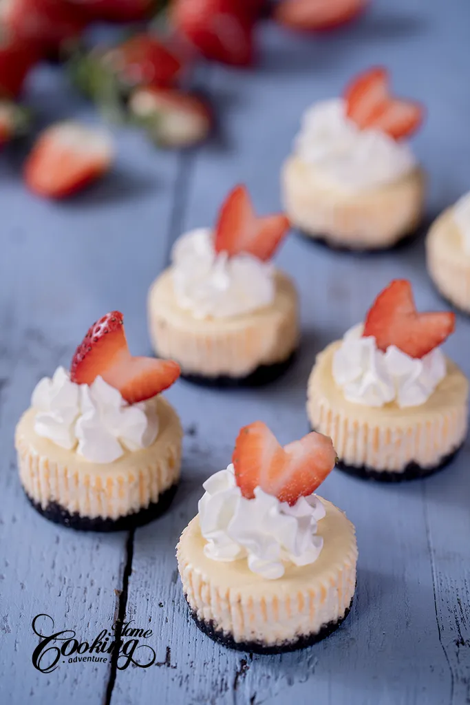 Mini Cheesecakes with Orea Crust, whipped cream topping and fresh strawberries.