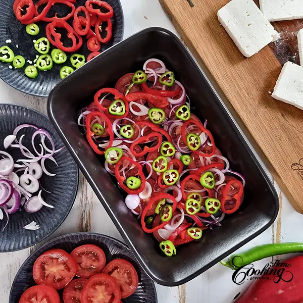 Layering the tomato and pepper slices on the bottom of the baking dish